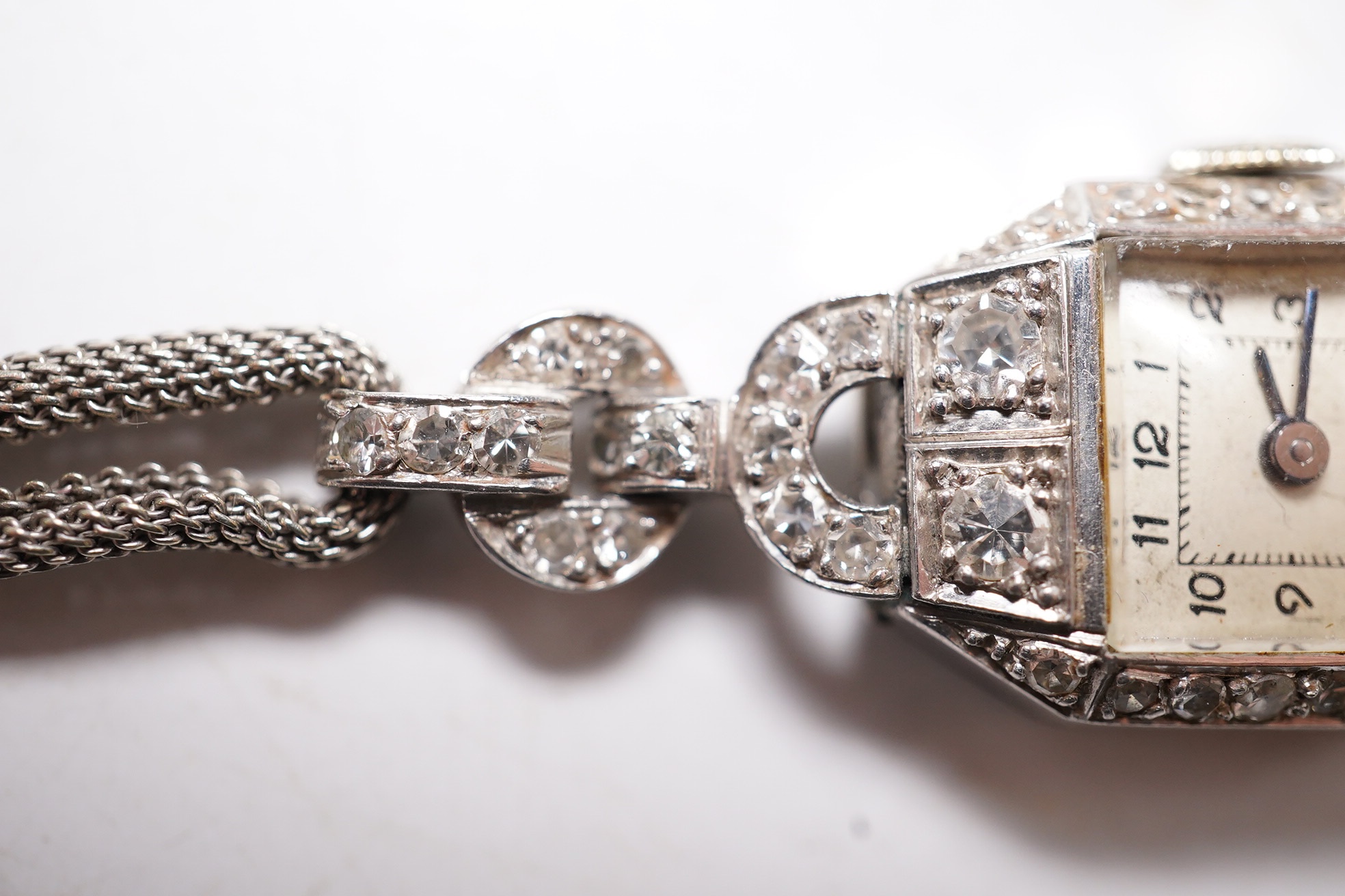 A lady's 1950's white metal and diamond cluster set manual wind cocktail watch, on a 9ct white gold bracelet, overall length 17.5cm, gross weight 17.1 grams. Condition - fair